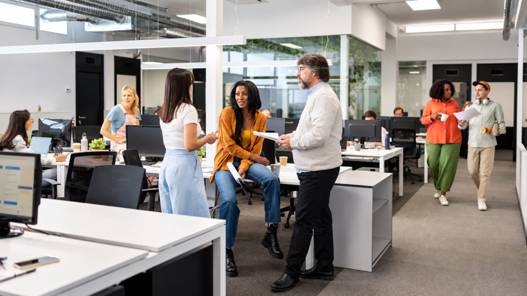 Colleagues talking in an open plan office